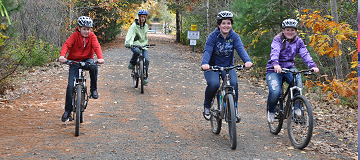 Children bike riding on park trail